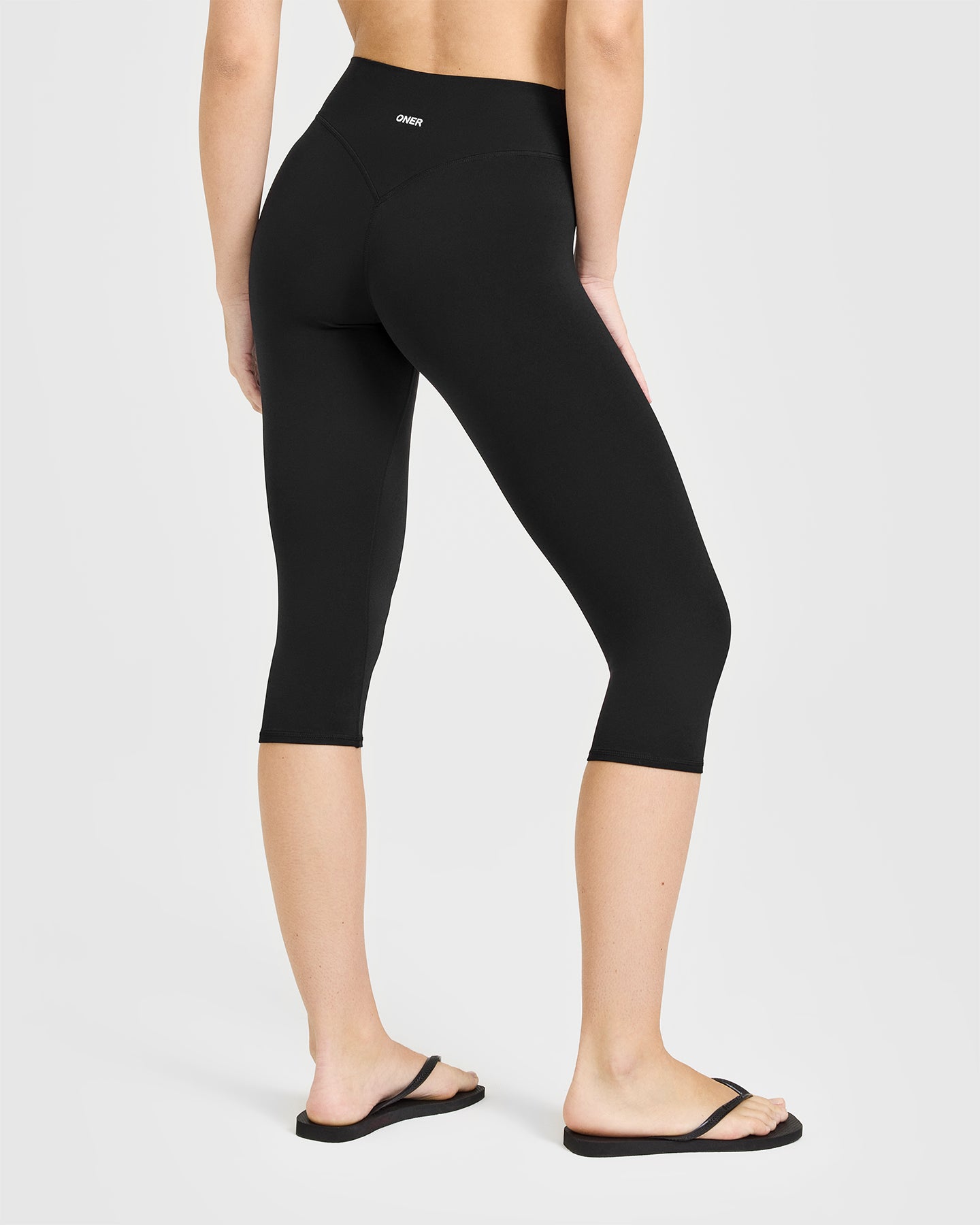SoftMotion™ High Waisted Capri Leggings with White Logo | Black